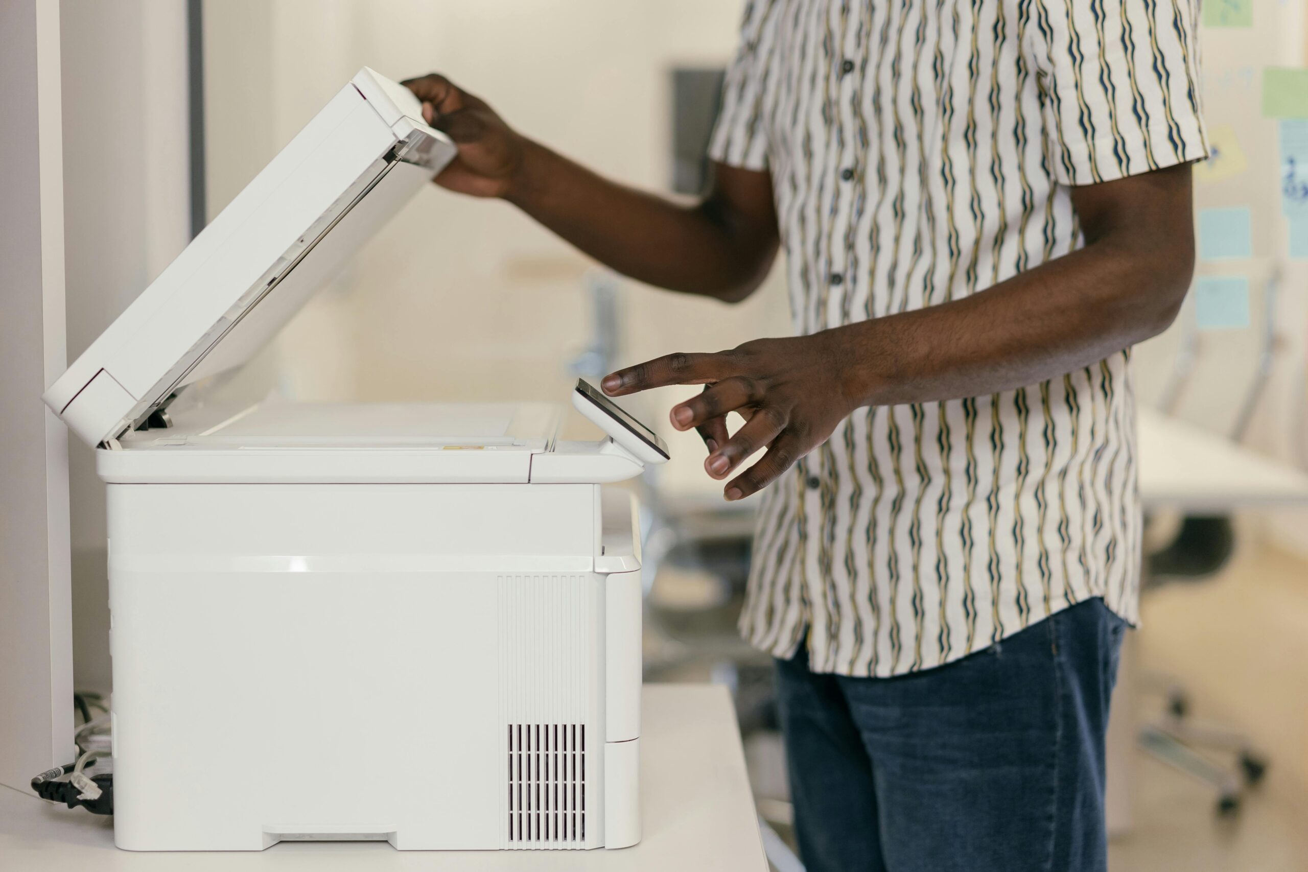 Person troubleshooting a printer at their desk